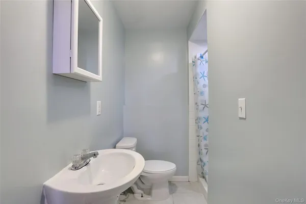 a bathroom with a sink a toilet and mirror