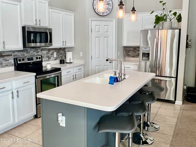 a kitchen with stainless steel appliances a stove refrigerator sink and microwave
