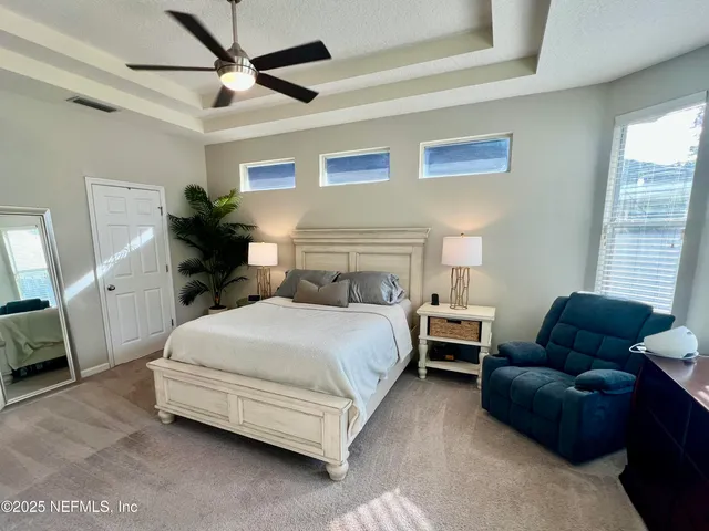 a bedroom with bed couch and window