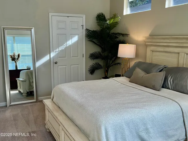 a bedroom with a bed and a potted plant