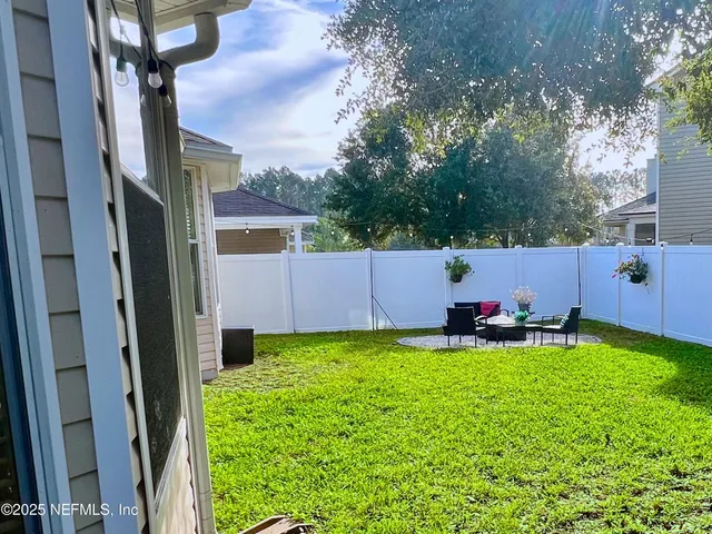 a backyard of a house with plants and wooden fence
