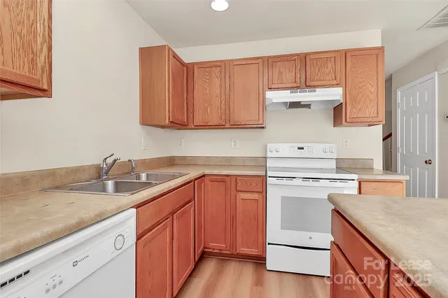 a kitchen with a sink a stove and cabinets