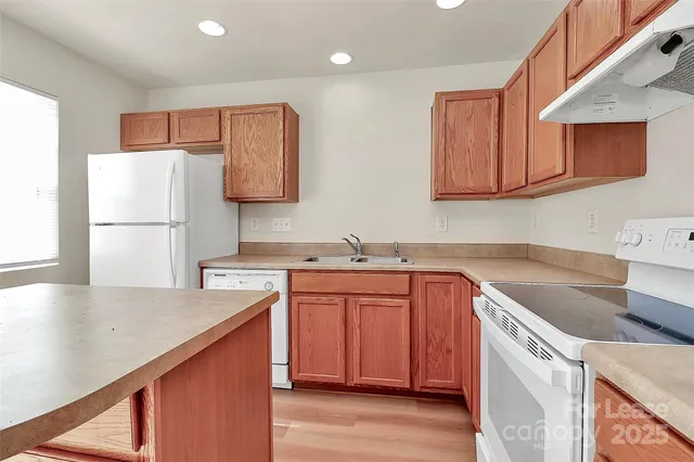 a kitchen with a sink a stove a refrigerator and cabinets