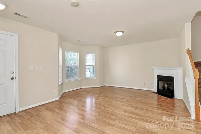 a view of an empty room with window and fire place