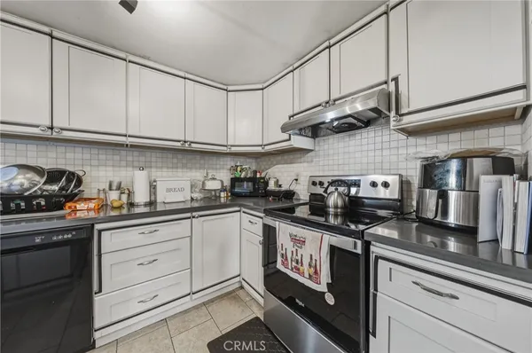 a kitchen with stainless steel appliances granite countertop a sink a stove and cabinets