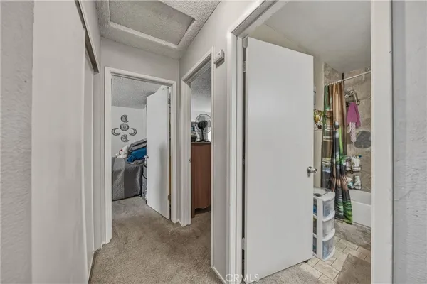 a view of a hallway with closet and a white floor to ceiling window