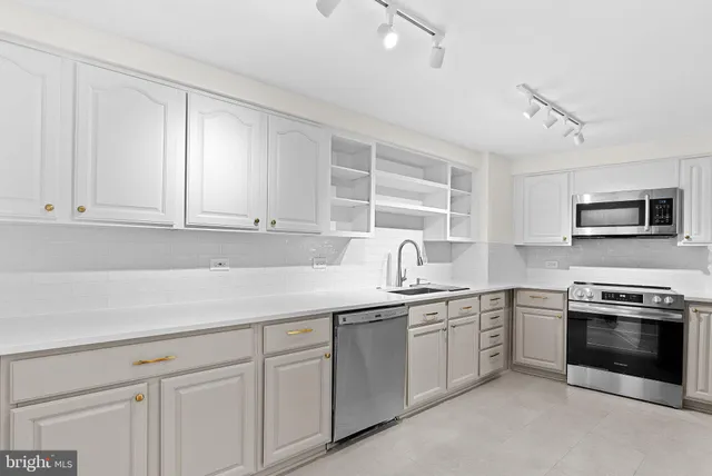 a kitchen with stainless steel appliances granite countertop a sink and cabinets with wooden floor