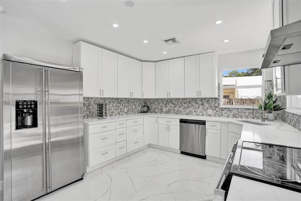 3421 Dover Road Pompano Beach, FL 33062 - Photo 18 of 22 a kitchen with granite countertop white cabinets and white stainless steel appliances