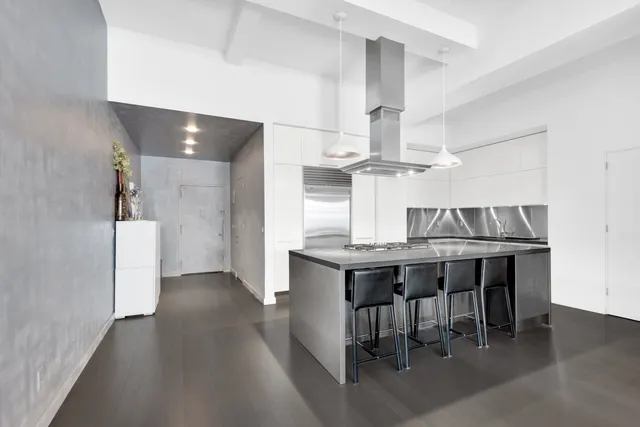 a kitchen with stainless steel appliances a table and chairs in it