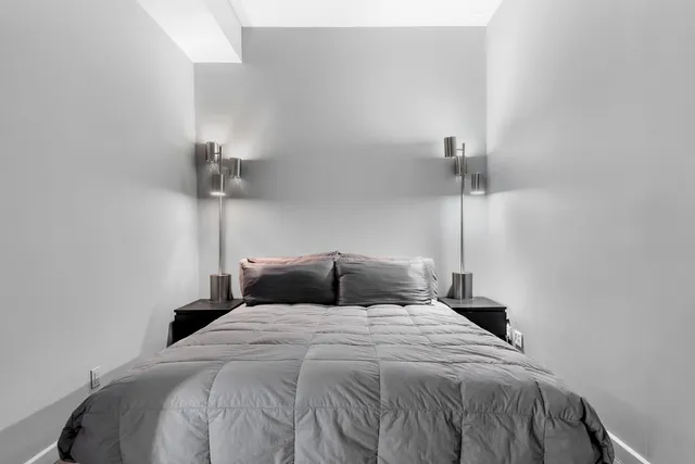 a bedroom with a bed and a night stand