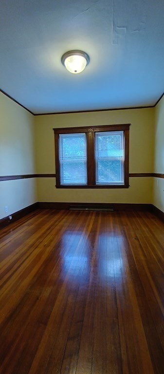 370 R Grove Boston, MA 02132 - Photo 5 of 12 a view of an empty room with wooden floor and a window