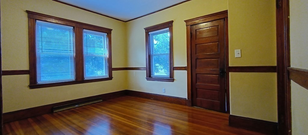 370 R Grove Boston, MA 02132 - Photo 7 of 12 an empty room with wooden floor and windows