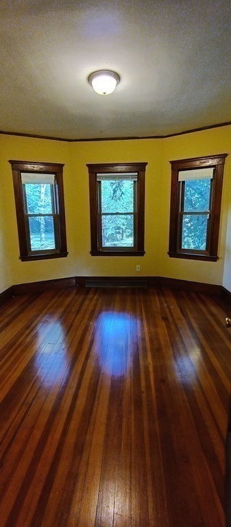 370 R Grove Boston, MA 02132 - Photo 8 of 12 a view of an empty room with wooden floor and painting on the wall