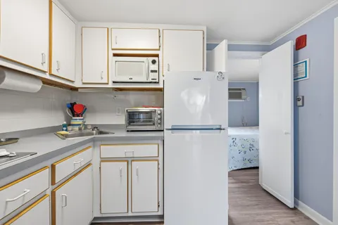a kitchen with stainless steel appliances white cabinets and a refrigerator