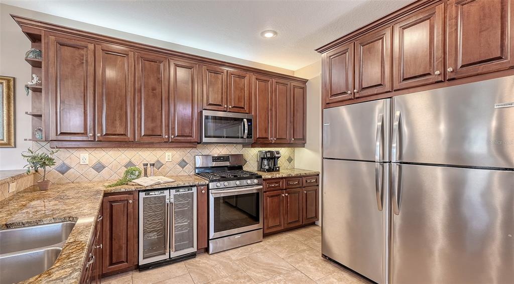 220 36th Street Holmes Beach, FL 34217 - Photo 17 of 59 a kitchen with stainless steel appliances granite countertop a refrigerator stove a sink and a microwave
