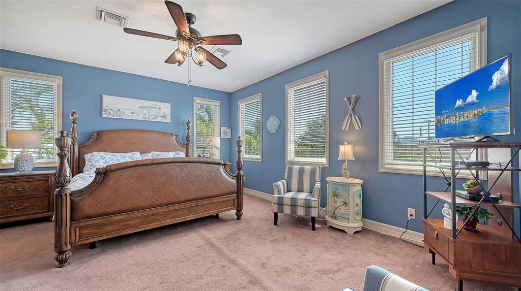 220 36th Street Holmes Beach, FL 34217 - Photo 20 of 59 a bedroom with a bed and a chandelier