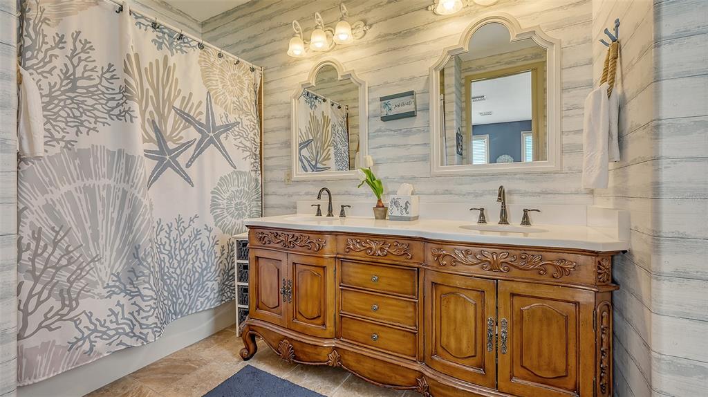 220 36th Street Holmes Beach, FL 34217 - Photo 22 of 59 a spacious bathroom with a granite countertop sink and a mirror
