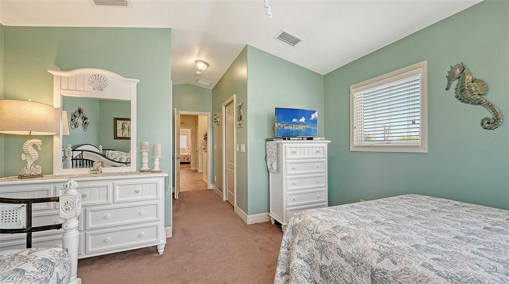 220 36th Street Holmes Beach, FL 34217 - Photo 26 of 59 a bedroom with a bed and a dresser in it