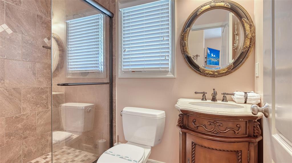 220 36th Street Holmes Beach, FL 34217 - Photo 30 of 59 a bathroom with a toilet a sink and a mirror