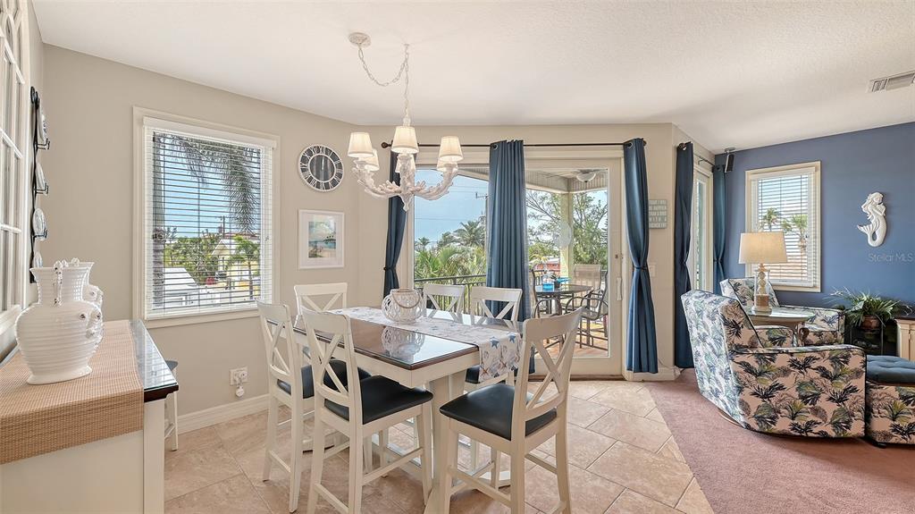 220 36th Street Holmes Beach, FL 34217 - Photo 10 of 59 a view of a dining room with furniture wooden floor and chandelier