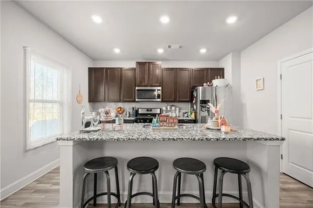 a large kitchen with granite countertop a stove a sink and a refrigerator