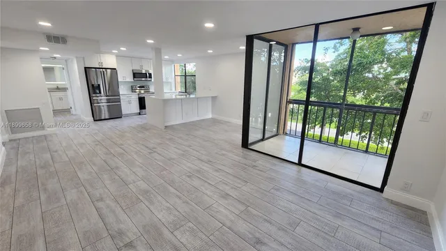 a view of a room with wooden floor and windows