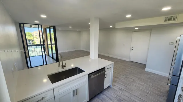 a kitchen with a sink and wooden floor