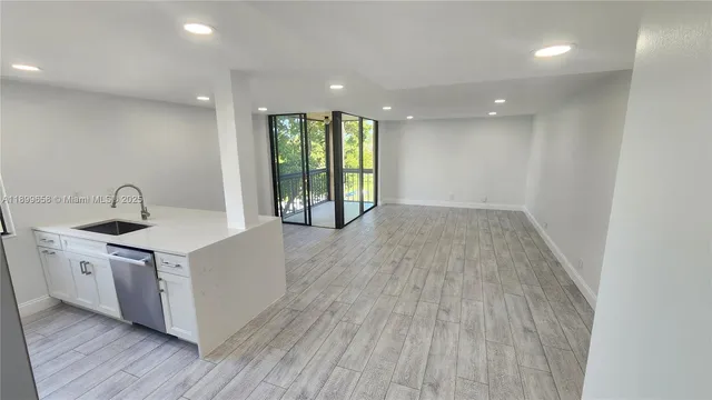 a kitchen with a sink and wooden floor