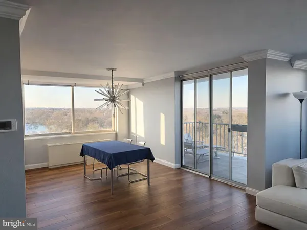 a bedroom with a bed a dresser and a large window