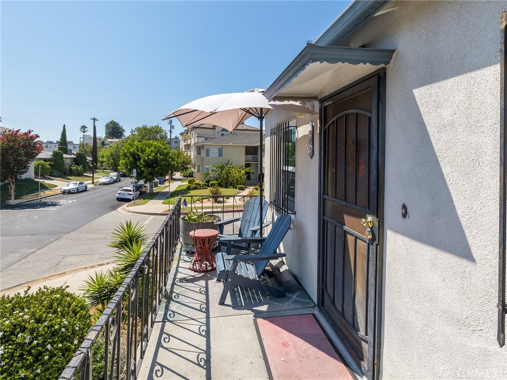 7019 Ramsgate Avenue Los Angeles, CA 90045 - Photo 5 of 19 a view of a patio with table and chairs under an umbrella with wooden floor