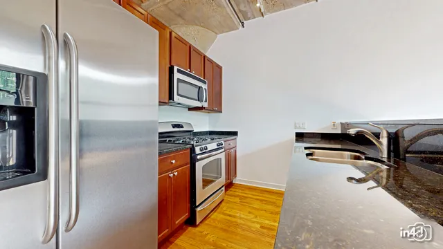 a kitchen with stainless steel appliances granite countertop a refrigerator and a stove