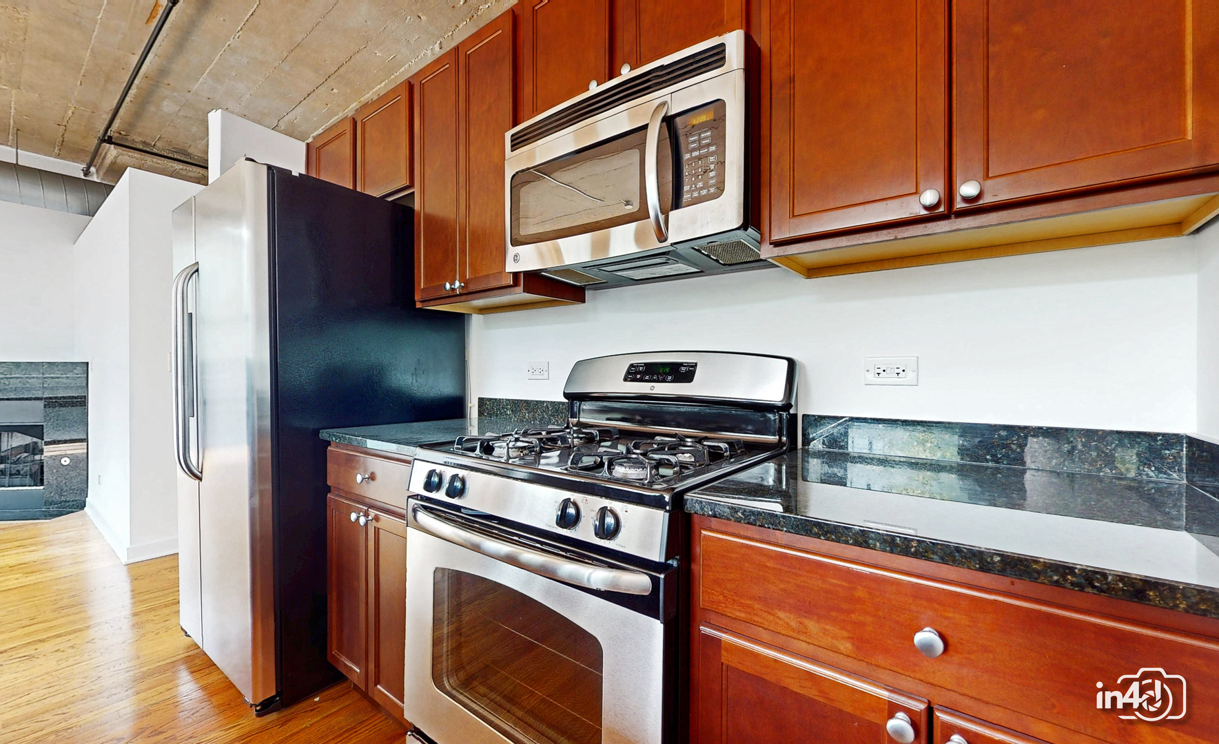 1150 West 15th Street, Unit 232 Chicago, IL 60608 - Photo 6 of 33 a kitchen with stainless steel appliances granite countertop a stove a microwave and a refrigerator