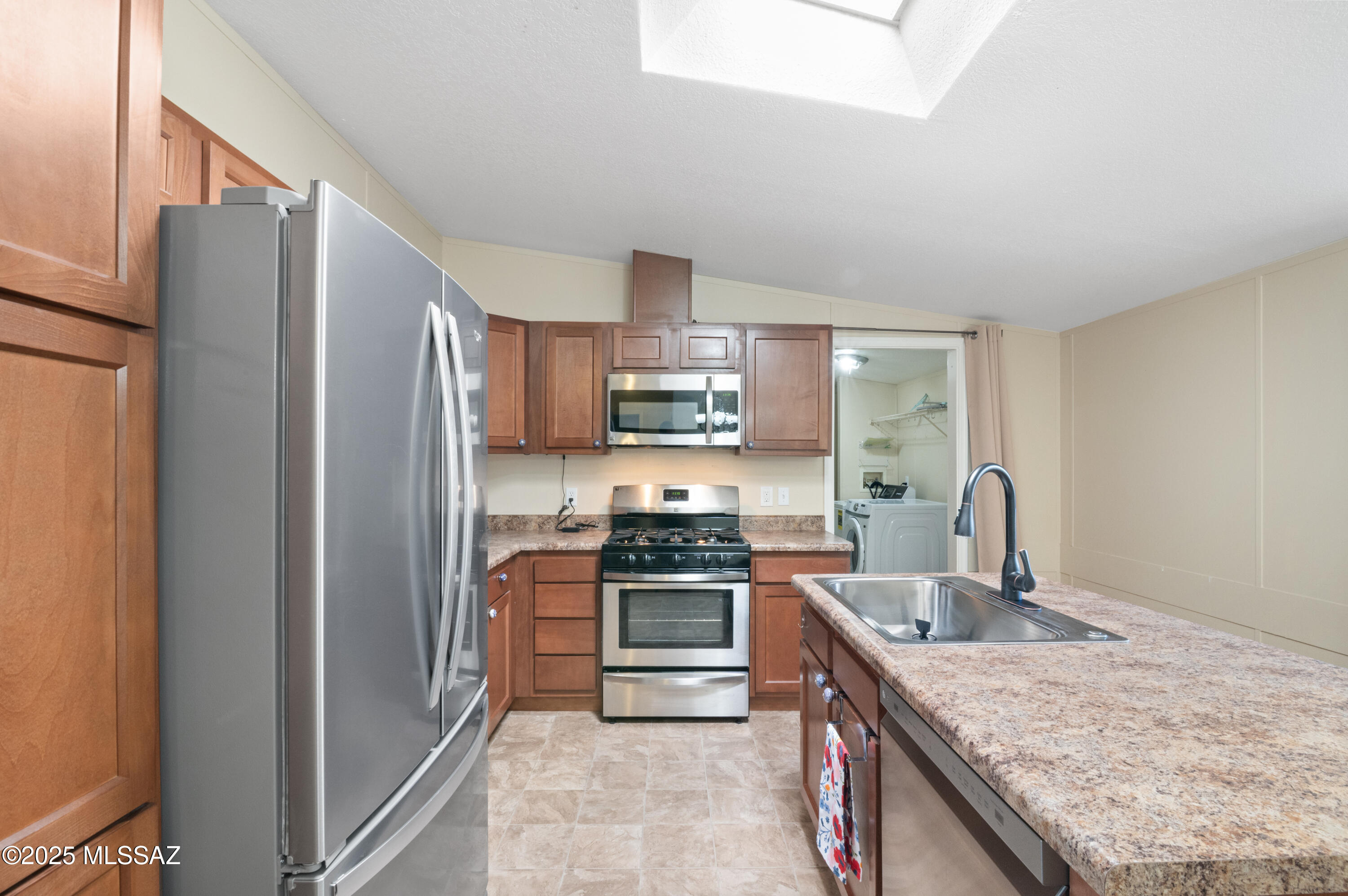 6205 East Rough Rock Drive Tucson, AZ 85756 - Photo 3 of 30 a kitchen with stainless steel appliances granite countertop a refrigerator a stove and a sink