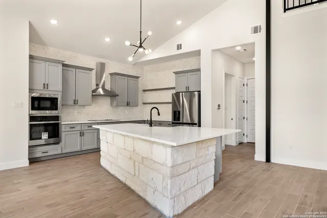 a large kitchen with stainless steel appliances kitchen island a large counter top and a sink