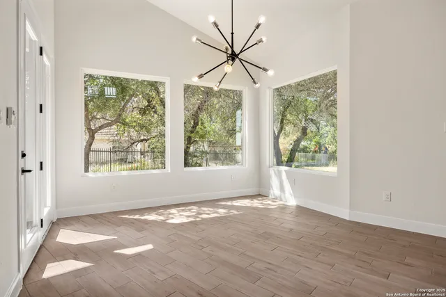 an empty room with wooden floor and fireplace