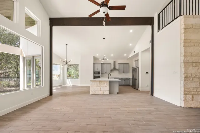 a large white kitchen with a large window appliances and cabinets