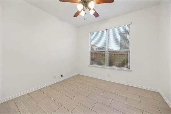 an empty room with chandelier fan