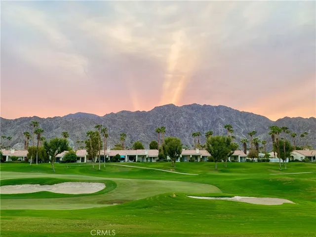 a view of grassy field with mountains in the background