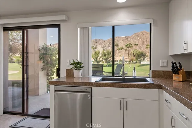 a kitchen with stainless steel appliances white cabinets and a large window
