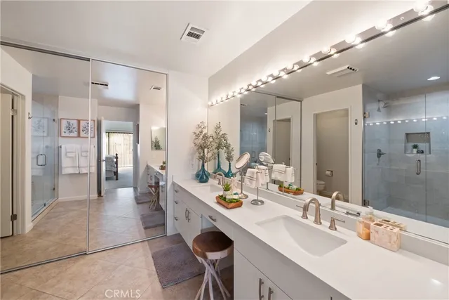a spacious bathroom with a double vanity sink mirror and shower