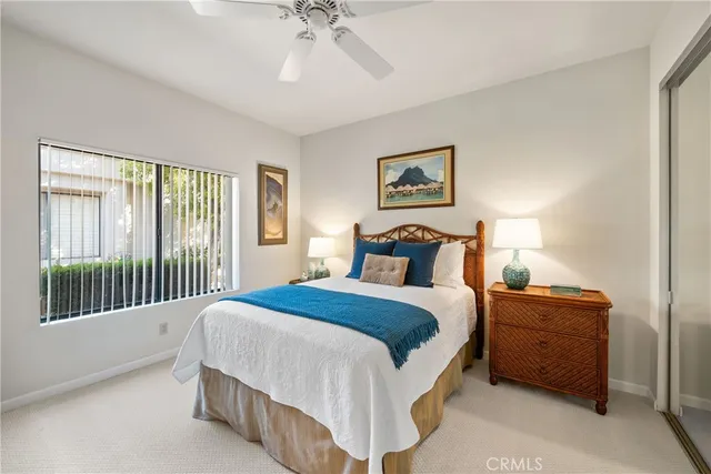 a bedroom with a balcony a bed and a painting on the wall