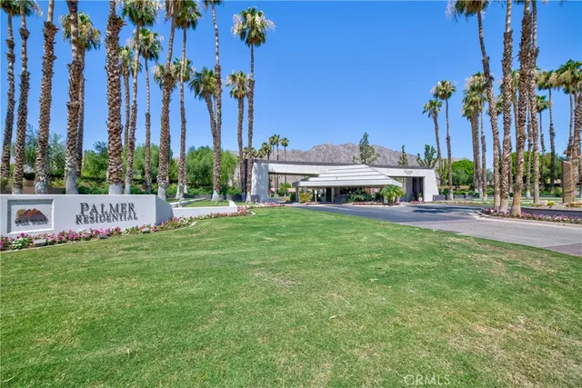 a view of a house with a yard and palm trees