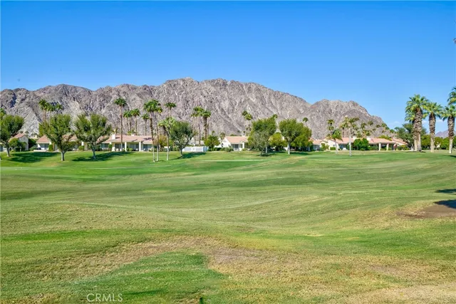 a view of a grassy field with mountains in the background