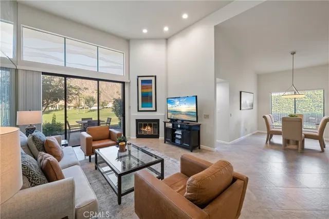 a living room with fireplace furniture and a large window