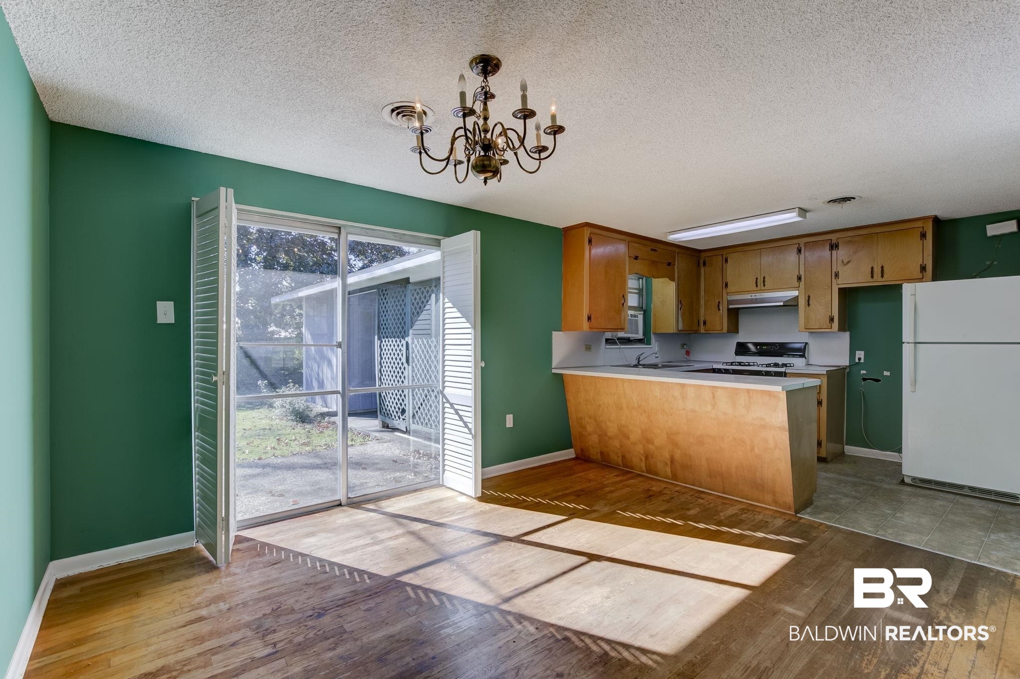 606 East Myrtle Avenue Foley, AL 36535 - Photo 6 of 24 Kitchen with kitchen peninsula, light hardwood / wood-style floors, white appliances, and a notable chandelier