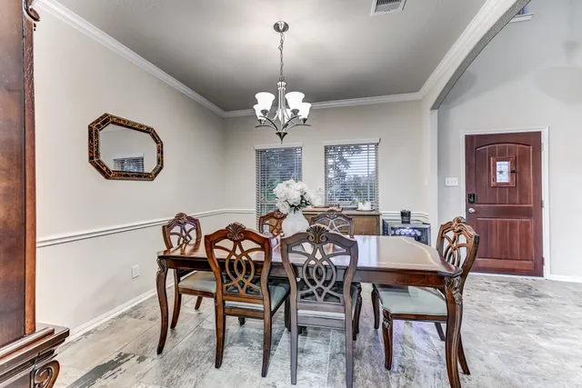 a view of a dining room with furniture and chandelier