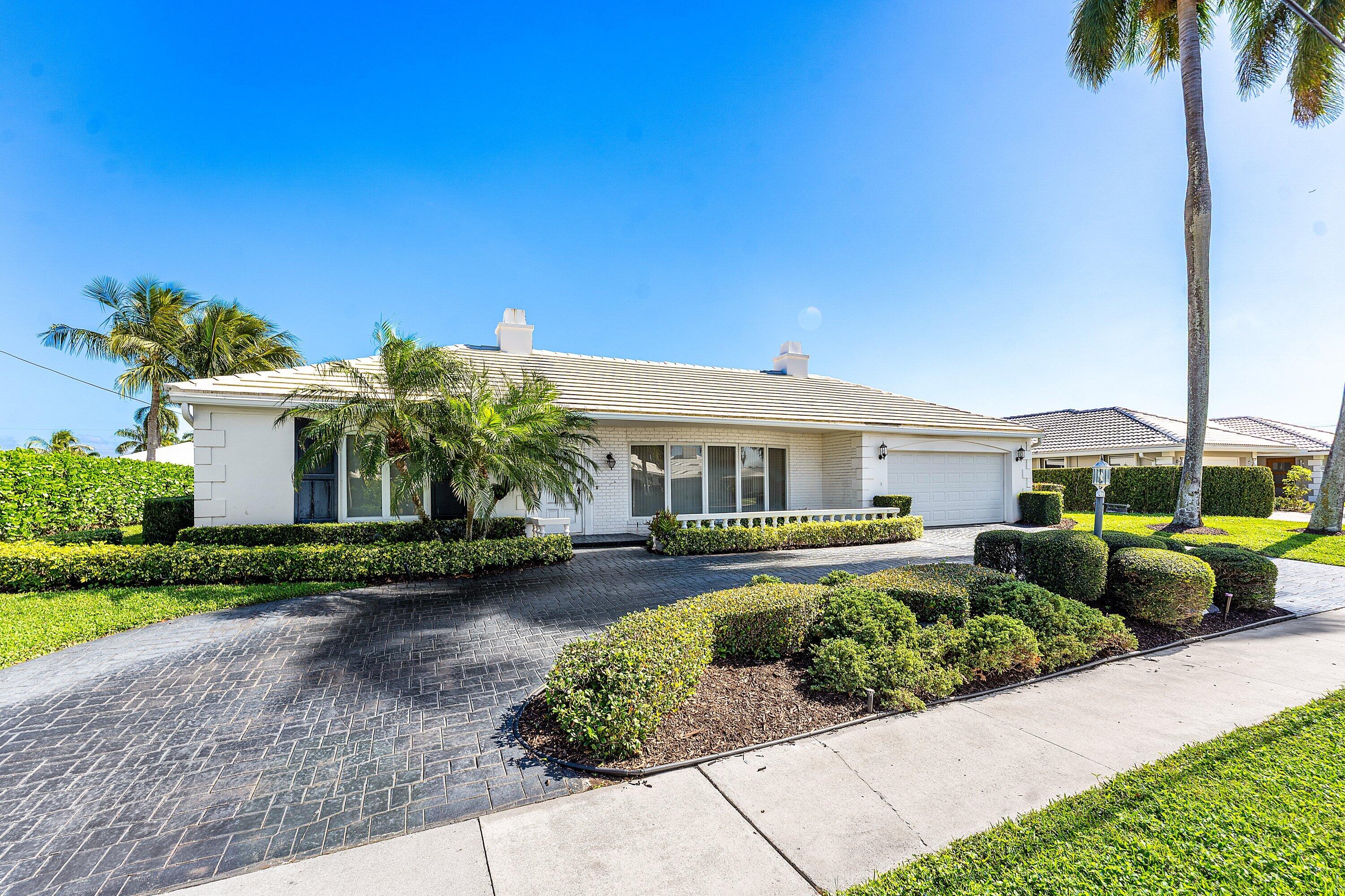 950 Mulberry Way Boca Raton, FL 33486 - Photo 4 of 23 a front view of a house with a garden and plants