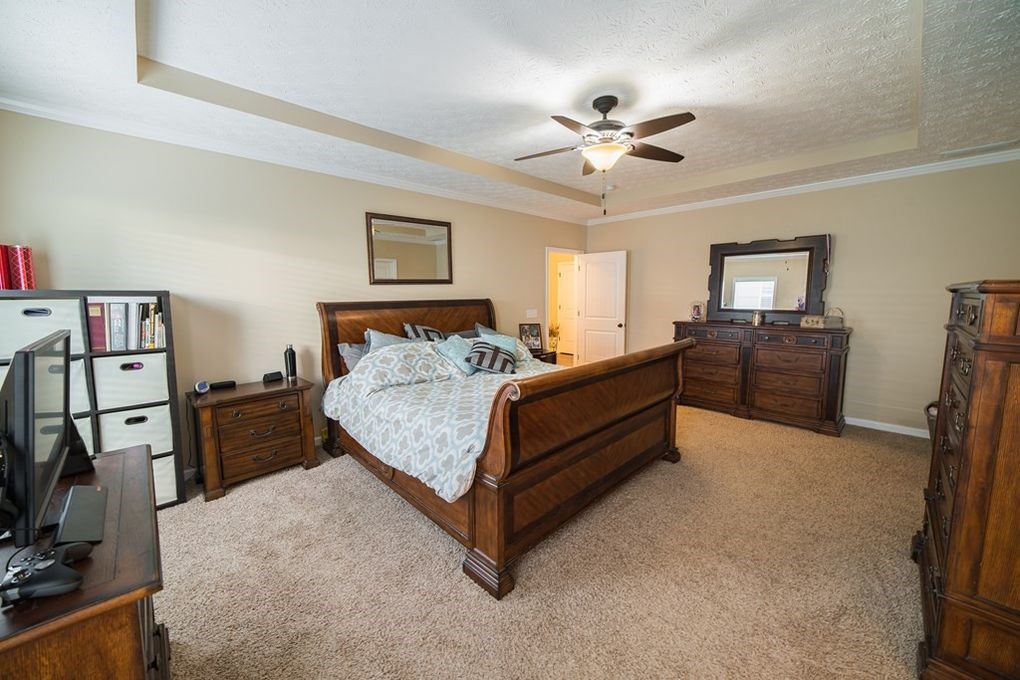 9570 Yarbrough Road Midland, GA 31820 - Photo 14 of 30 a bedroom with a large bed and a chandelier