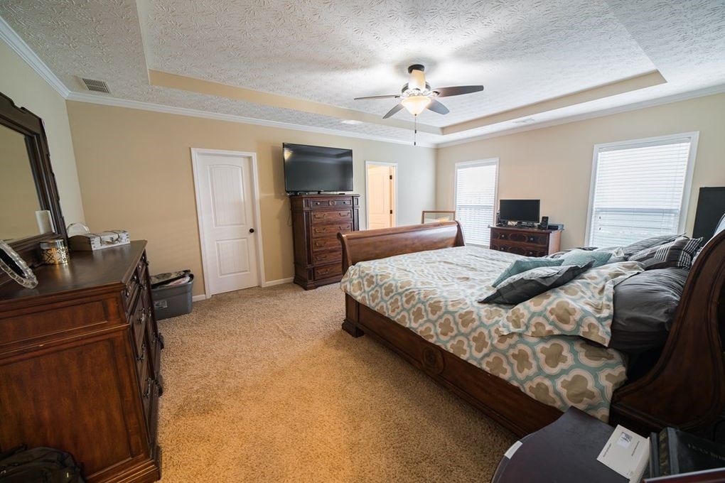 9570 Yarbrough Road Midland, GA 31820 - Photo 15 of 30 a bedroom with a bed and a chandelier