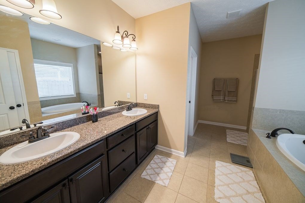9570 Yarbrough Road Midland, GA 31820 - Photo 17 of 30 a bathroom with a granite countertop sink a toilet a mirror and bathtub